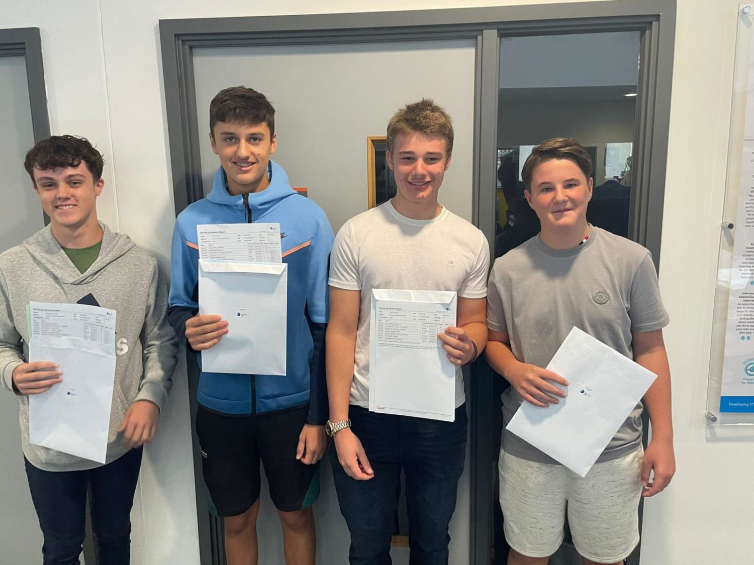 A group of students posing for a photo with their results
