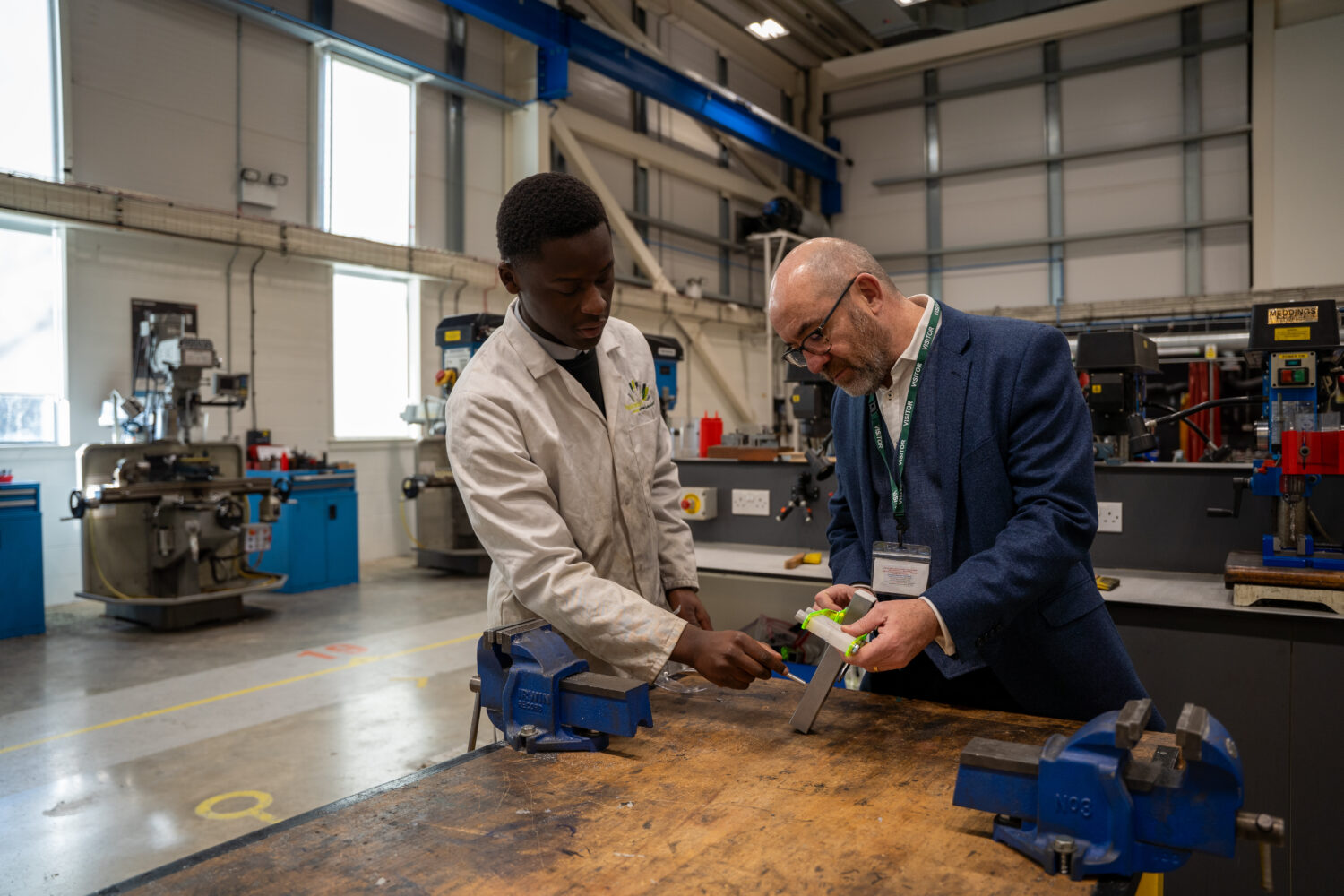 Labour minster looking at a machine with a student